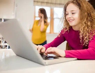 Chicos estudiando desde casa con una computadora